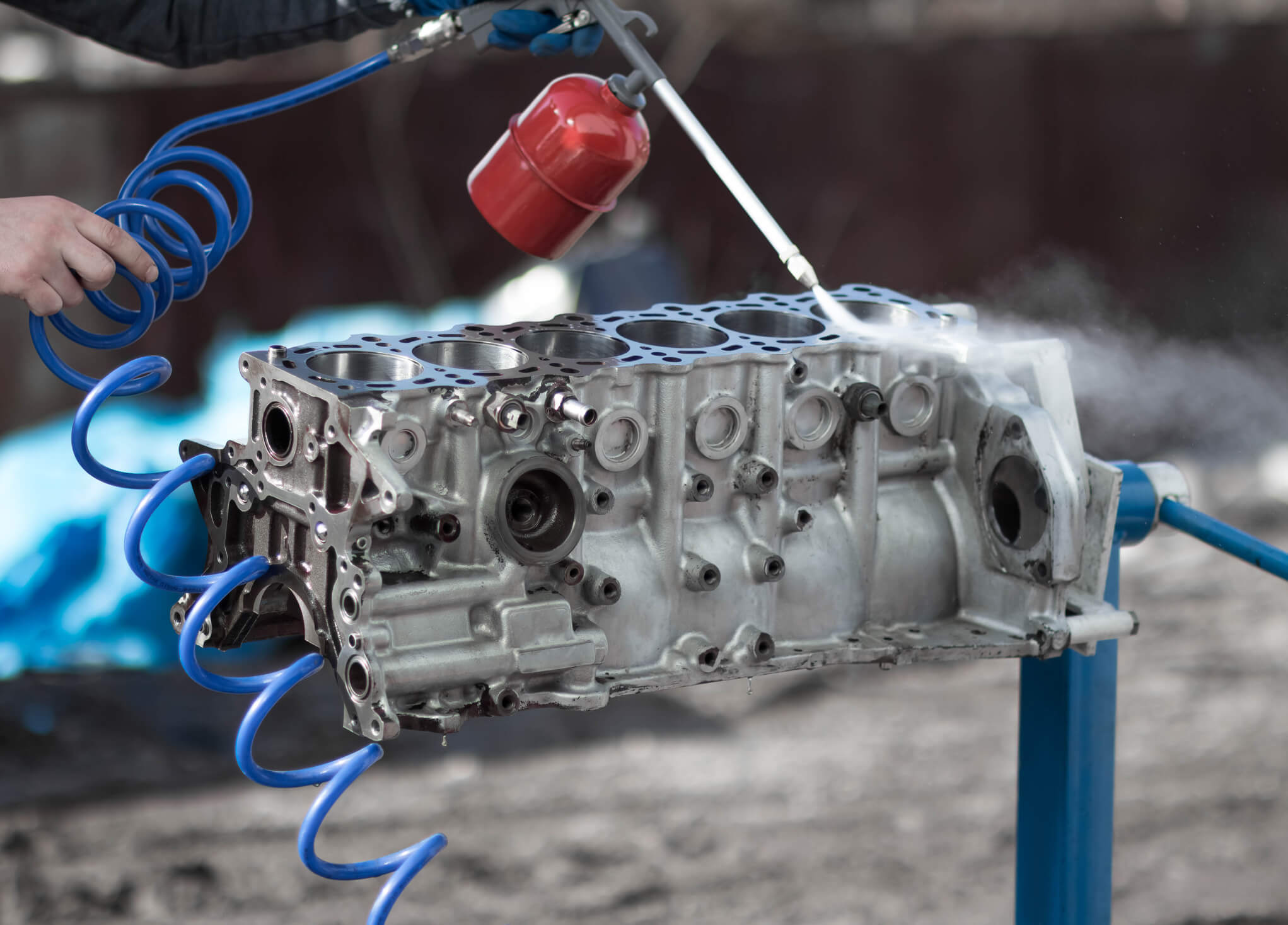 Image of an engine block being sprayed with Cyclopentatnone cleaning solution