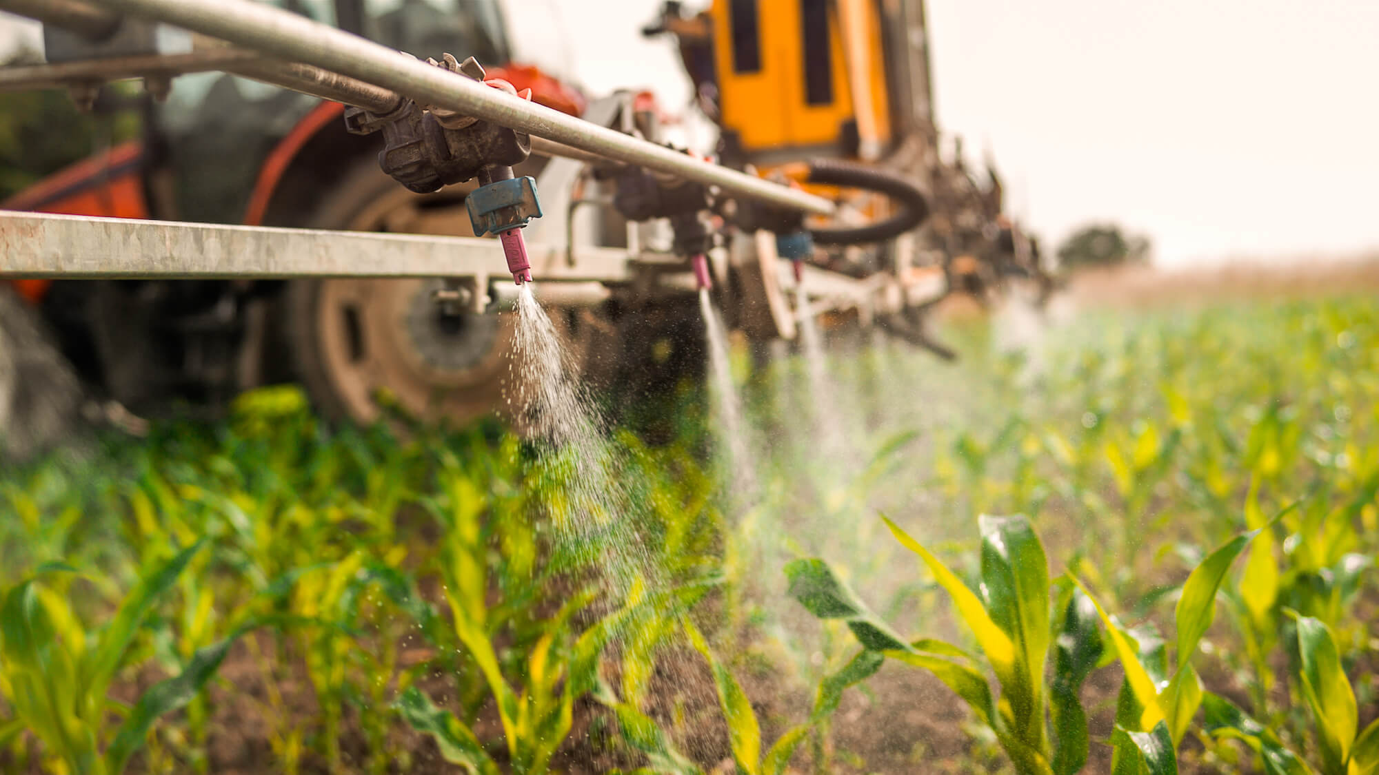 Cyclopentyl Methyl Ether is being sprayed out of a herbicide sprayer mounted to a tractor